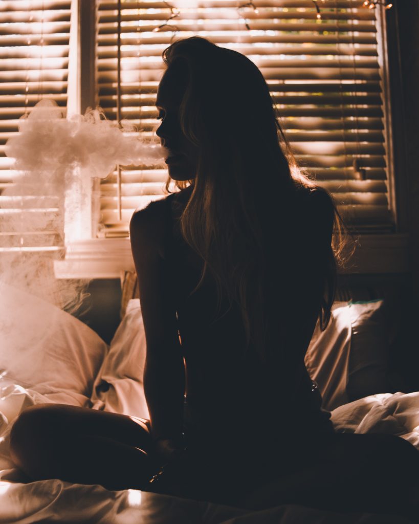 Some researchers have found connection between cannabis and violence as woman smokes in room.