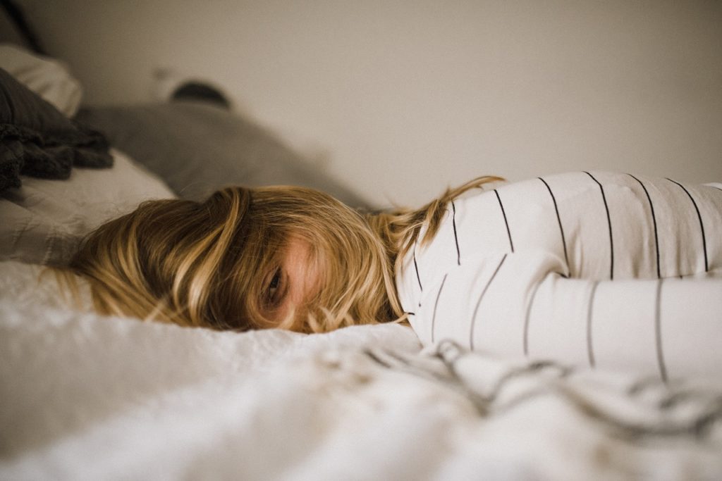 A woman laying on a bed, representing a customer from the CBD store in Mainz