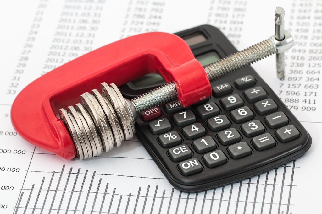 a clamp and a calculator, sitting on a document representing stocks for Aurora Cannabis