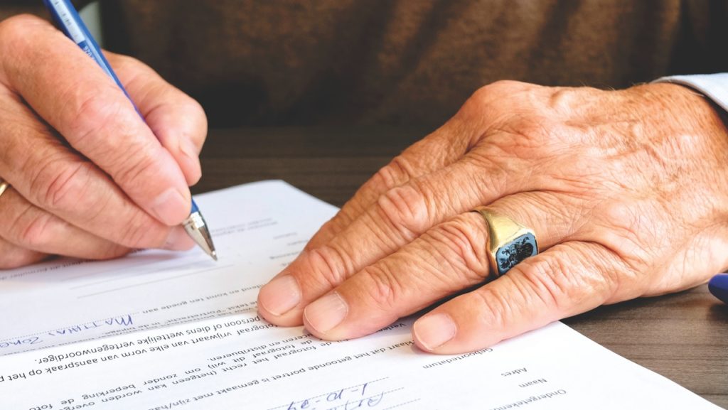 Someone signing documents representing laws about cannabis in Spain