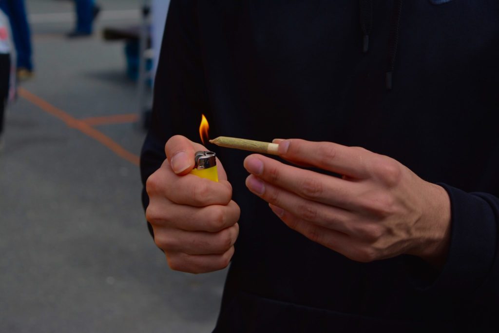 A person lighting a joint to represent the Canadian cannabis market