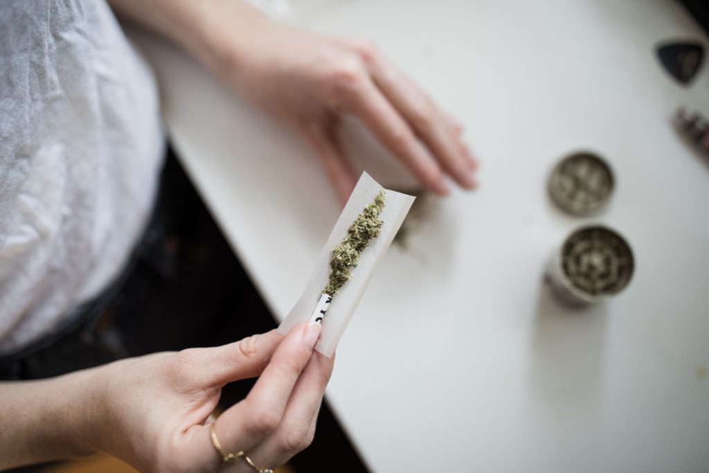 A woman rolling a joint representing treating endometriosis with THC