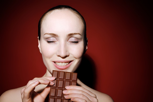 a woman eating chocolate representing cannabis edibles in Italy